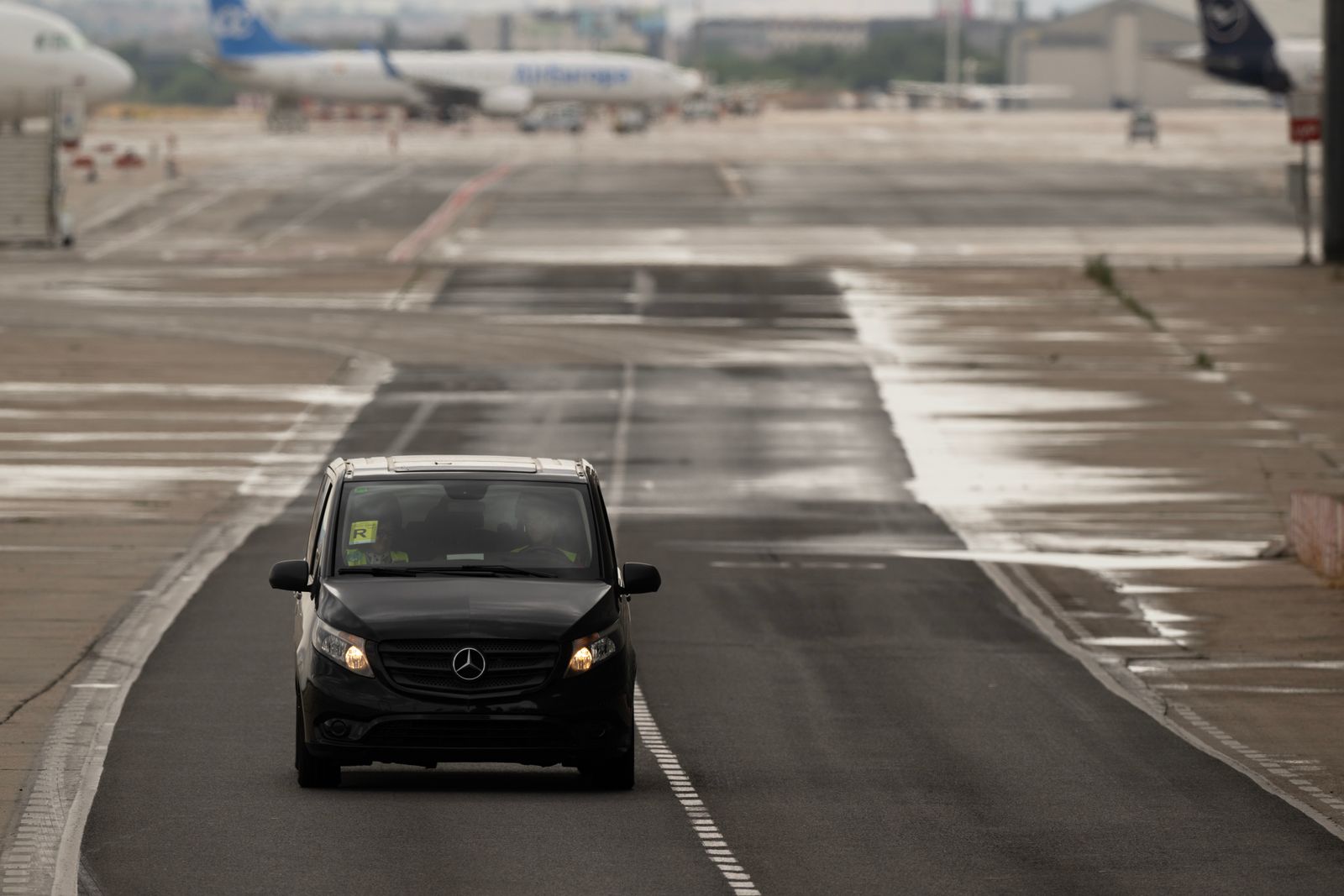 Black executive car waiting on an airport apron