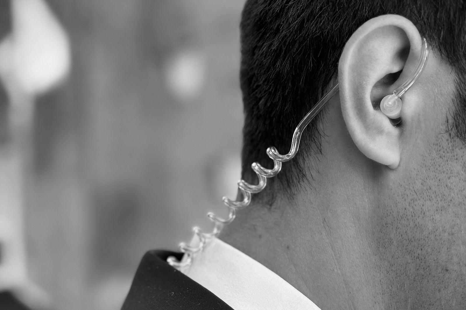 Close protection officer in a dark suit wearing a discreet earpiece