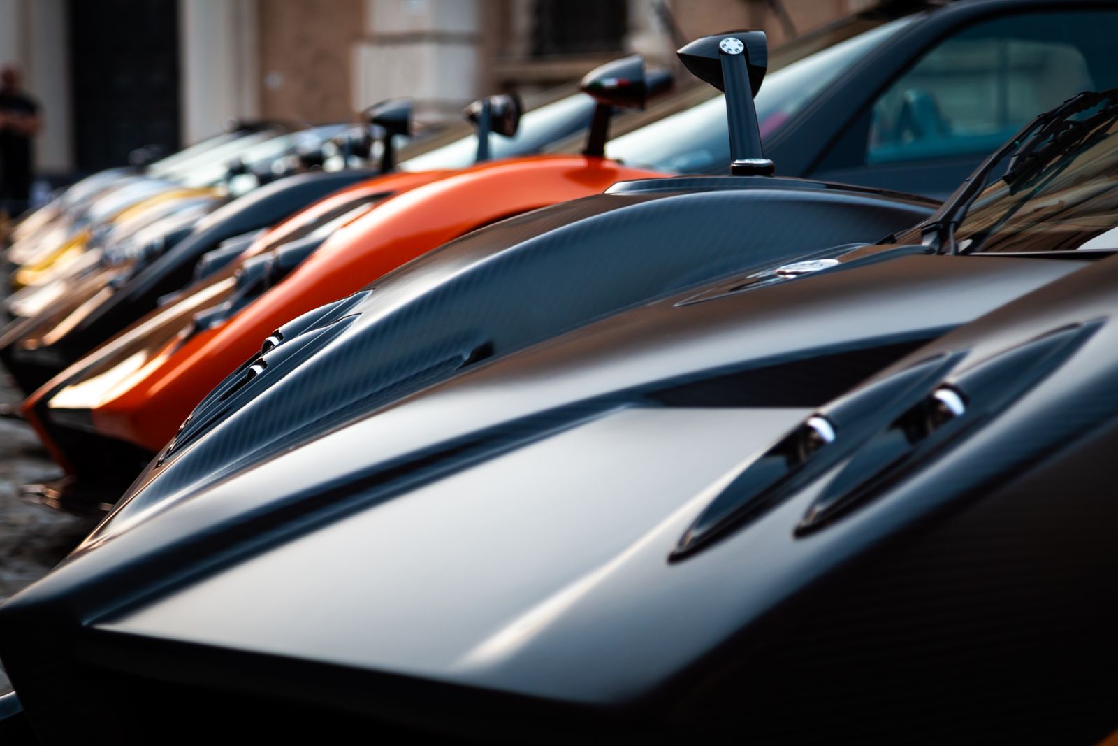 Row of luxury supercars parked in a private showroom