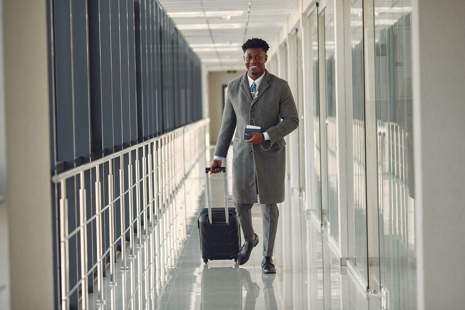 Business traveller walking through an airport terminal with luggage